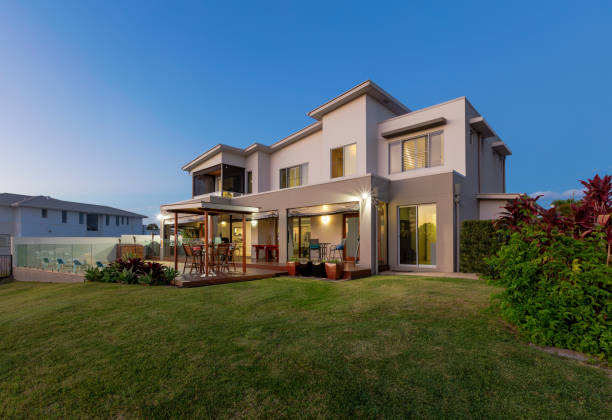 Modern multilevel house exterior with pool at dusk